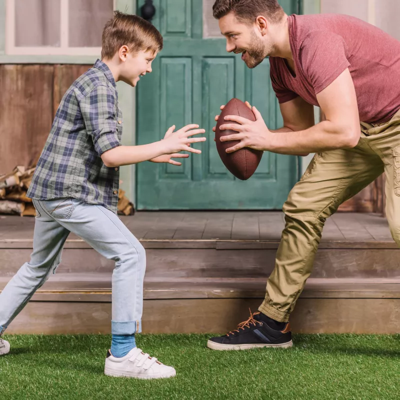 Father and son playing a backyard game of football.