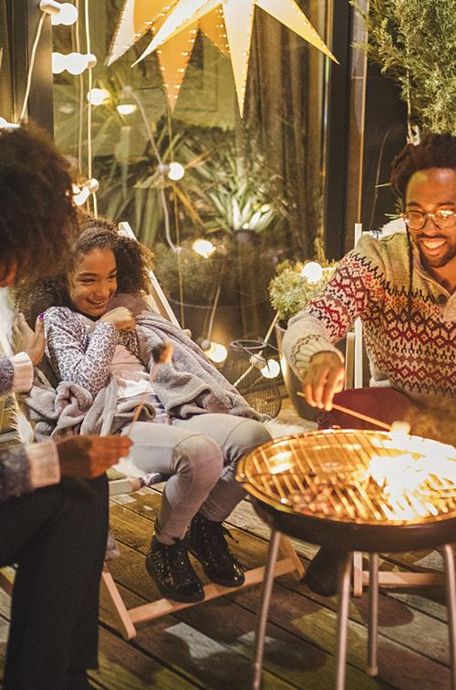 A family roasting marshmallows outside. 