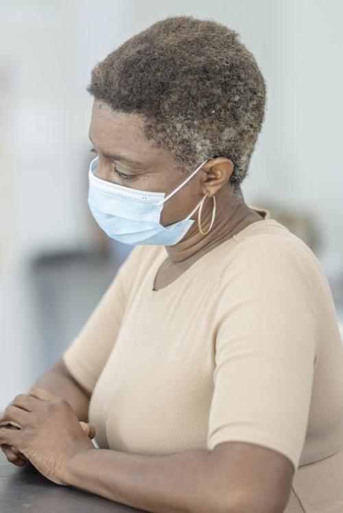 A woman at the doctor wearing a mask.